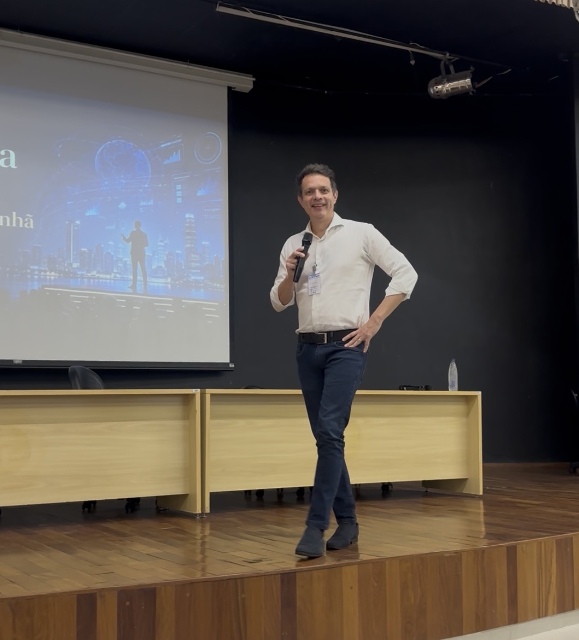 Augusto Salomon palestrando em auditório com telão da palestra Construindo o Amanhã